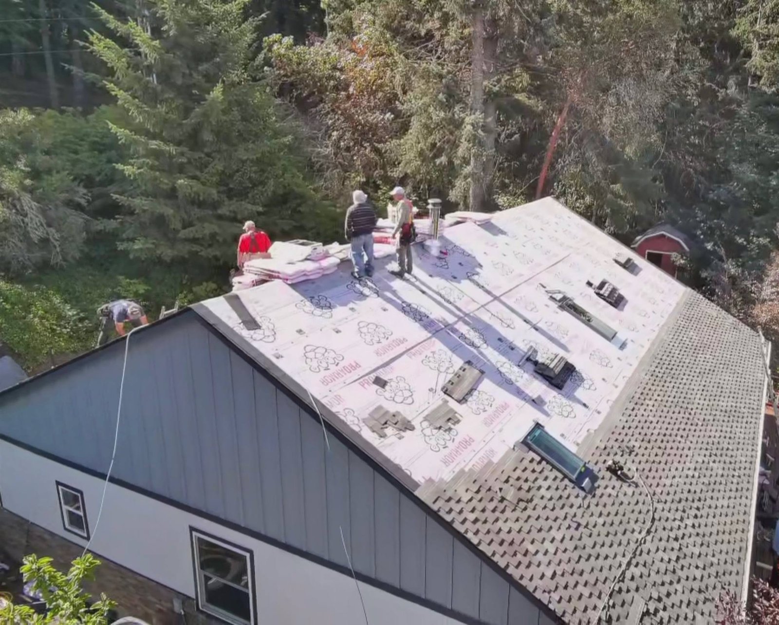 Crew on the roof with the underlayment down and shingles going on