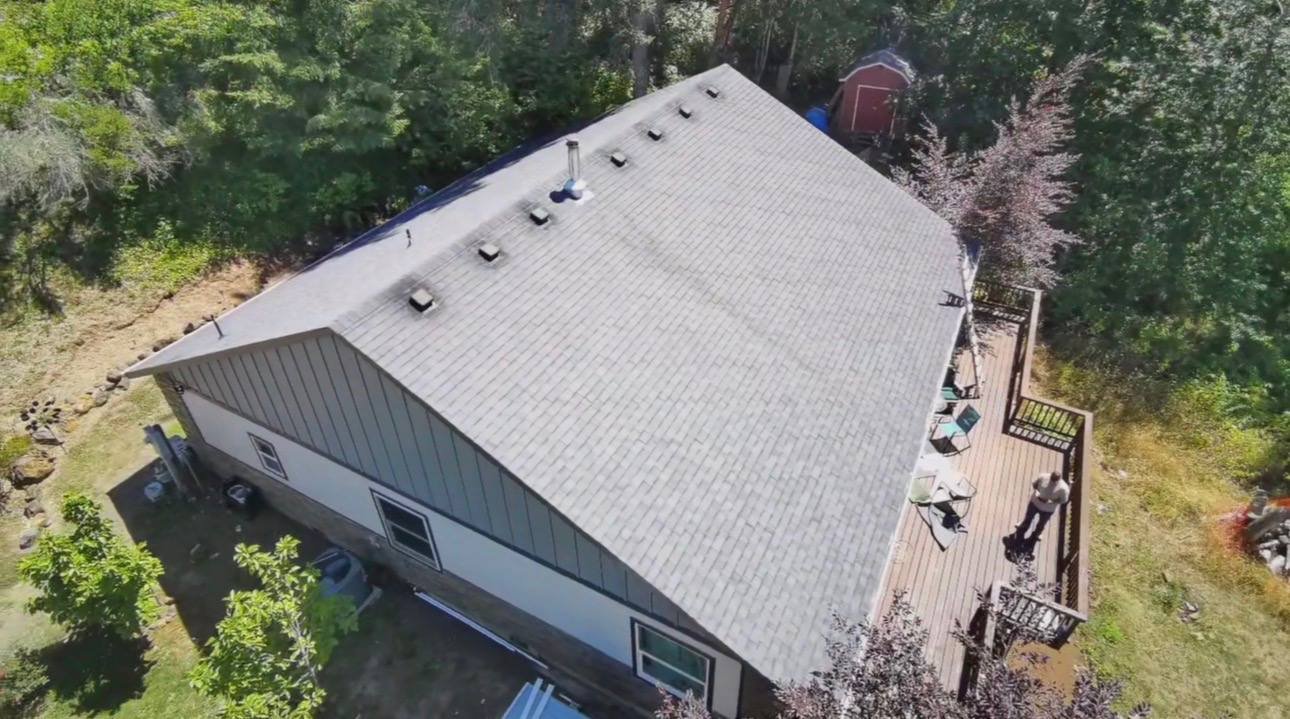 A ranch style house from above with a pale, worn roof