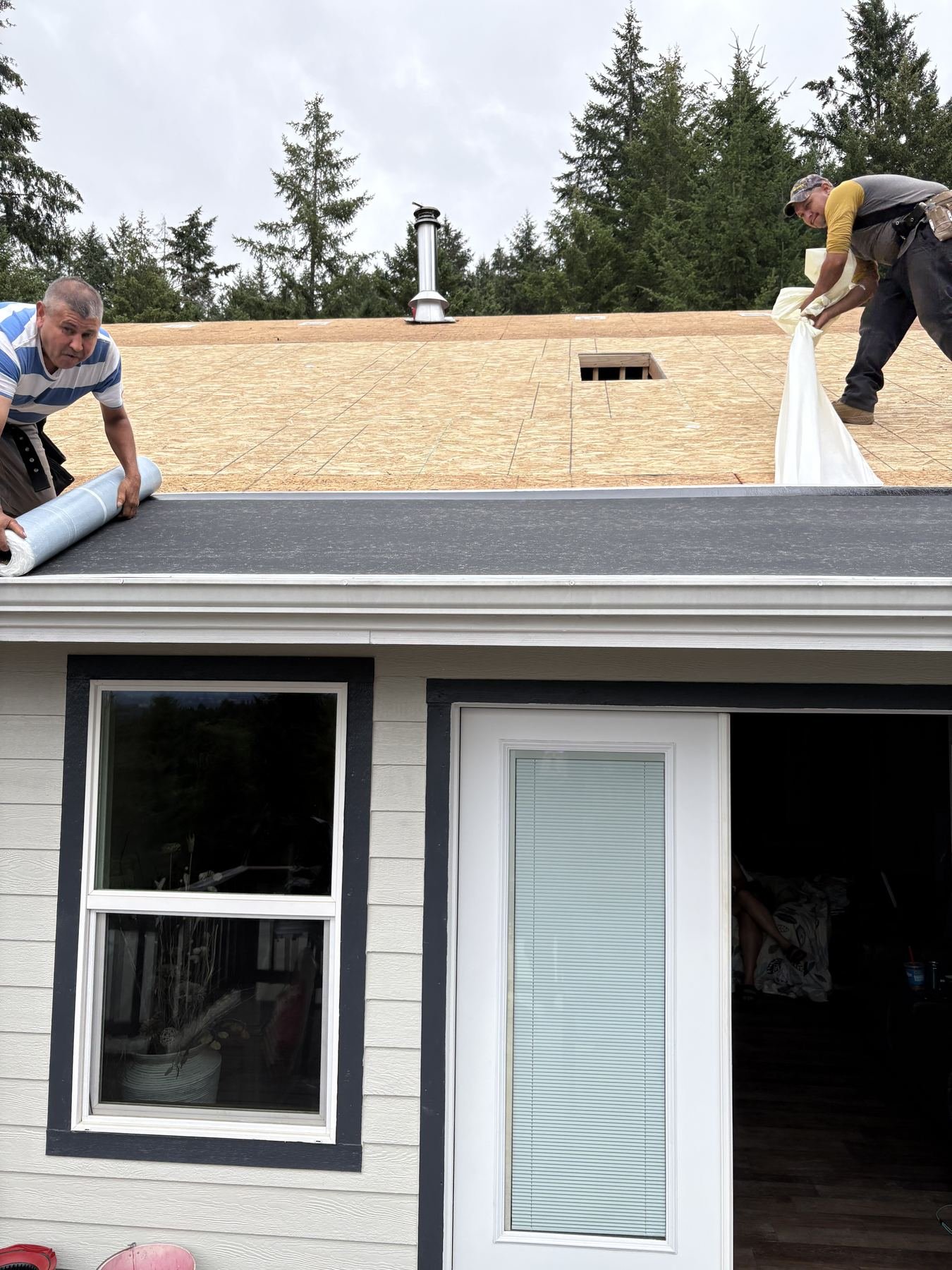 Synthetic underlayment being rolled out over the new decking